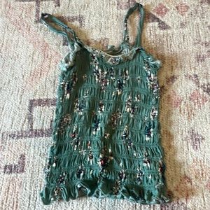 This is a tank top that is green with flowers barley used, and is the size S